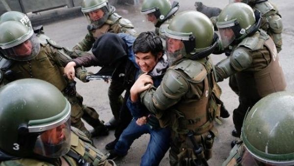 A demonstrator is detained by riot police during a protest against government education reforms in Valparaiso city, Chile, June 9, 2016.