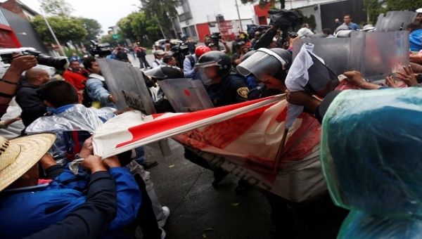 Teachers clash with riot police as they take part in a march against President Enrique Pena Nieto's education reform in Mexico City, Mexico, June 3, 2016.