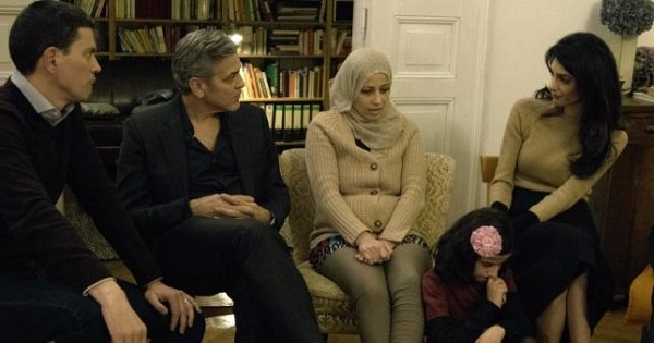 Amal Clooney and her husband George Clooney meet with Syrian refugees Mona and her daughter, 11-year-old Joudi, in Berlin, Germany Feb. 12, 2016.