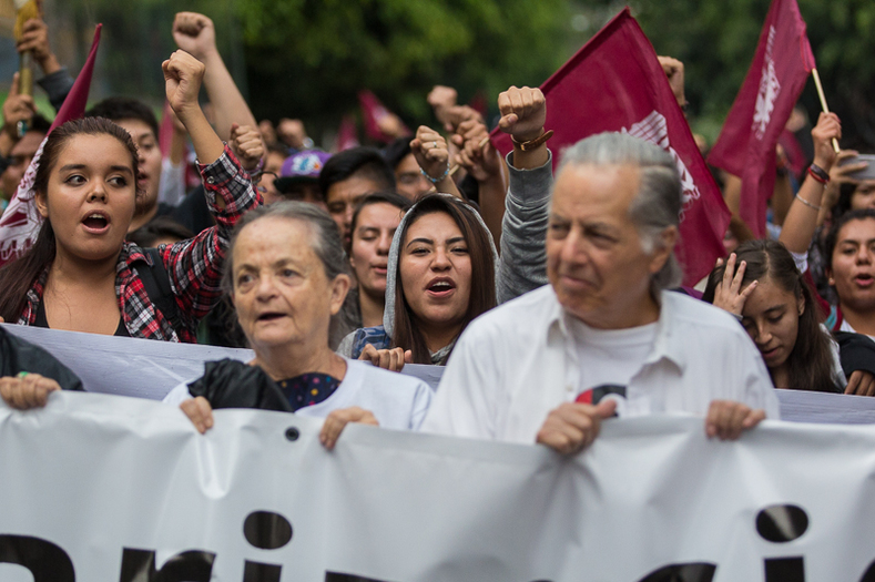 Behind the members of the Comite 68 are current students of the National Polytecnic Institute, IPN. In 1971, 120 students from IPN were killed in the state-sponsored Halconazo massacre, while they were holding a march.