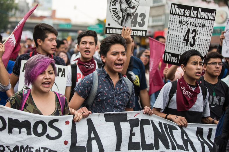 The thousands who participated in the Friday march carried signs demanding justice in the case of the disappeared 43 Ayotzinapa students.