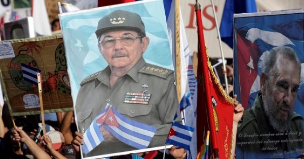 People carry pictures of Cuba's president Raul Castro and his brother and Cuba's former President Fidel Castro during a parade in Havana