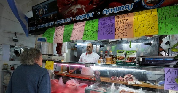 A customer buys meat at a butcher's shop in Buenos Aires.