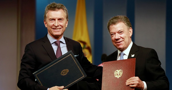 Colombia's President Juan Manuel Santos (R) and Argentina's President Mauricio Macri pose with agreements folders in Bogota Colombia, June 15, 2016.
