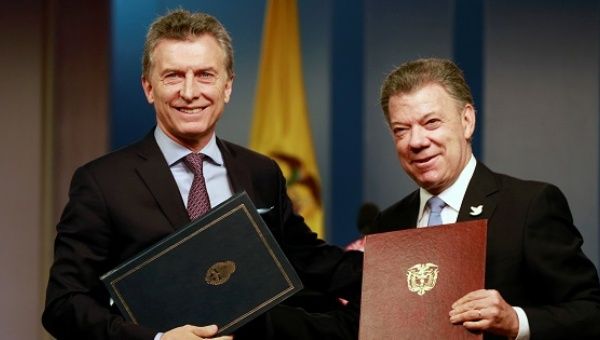 Colombia's President Juan Manuel Santos (R) and Argentina's President Mauricio Macri pose with agreements folders in Bogota Colombia, June 15, 2016.