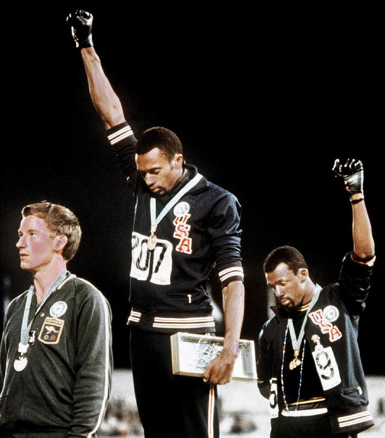 Gold medallist Tommie Smith (center) and bronze medalist John Carlos (right) showing the raised fist on the podium after the 200 m race at the 1968 Summer Olympics in Mexico; both wear Olympic Project for Human Rights badges. Peter Norman (silver medalist, left) from Australia also wears an OPHR badge in solidarity to Smith and Carlos.