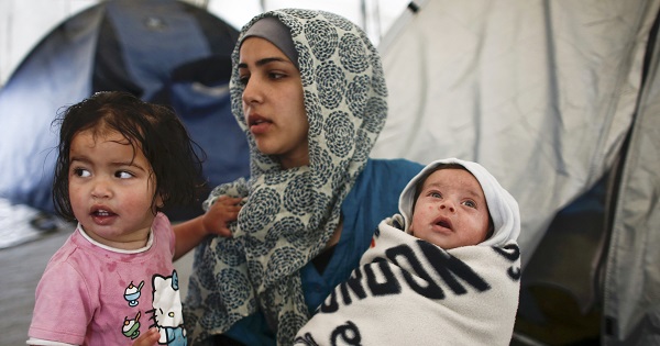 A Syrian refugee woman holds her 40-days old son at a makeshift camp at the Greek-Macedonian border near the village of Idomeni, Greece, May 20, 2016.
