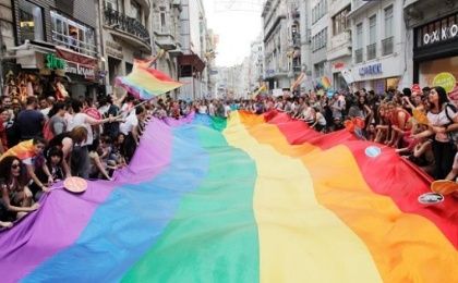 People hold a giant rainbow flag during a gay parade on June 30, 2013 in Istanbul.