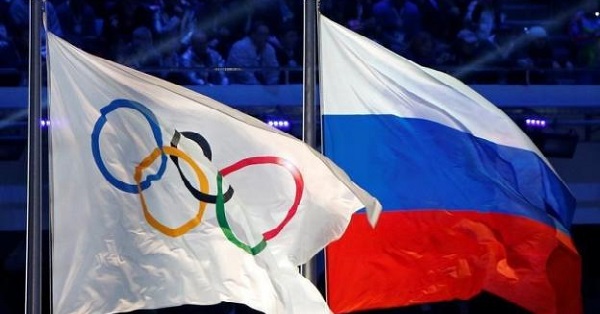 The Russian national flag (R) and the Olympic flag are seen during the closing ceremony for the 2014 Sochi Winter Olympics, Russia, February 23, 2014.