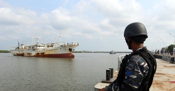 An Indonesian Navy officer in April, standing before a Chinese trawler that was allegedly operating illegally in Indonesian waters.