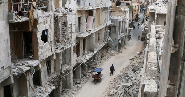 Residents walk near damaged buildings in the anti-government held area of Old Aleppo, Syria.