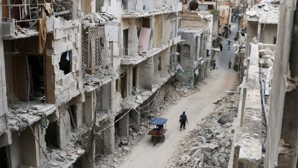 Residents walk near damaged buildings in the anti-government held area of Old Aleppo, Syria.
