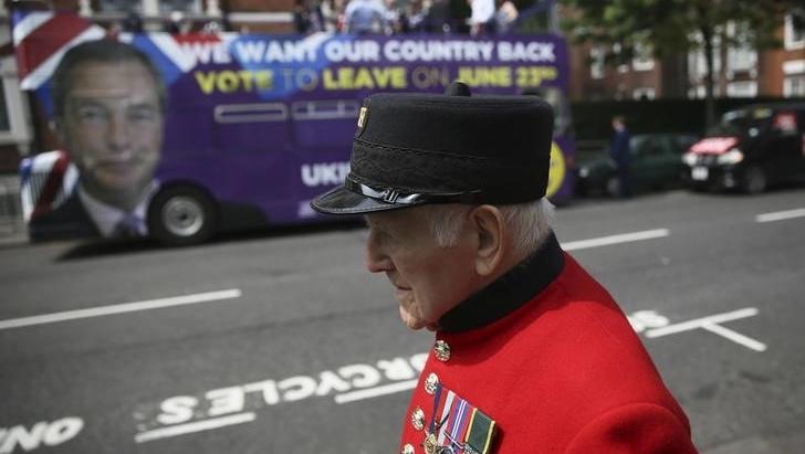 A Chelsea Pensioner passes in front of the UK Independence Party (UKIP) pro-brexit campaign bus, parked in front of the Chelsea Flower Show in London
