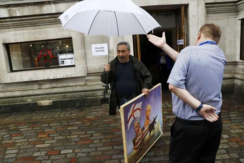 A man carries a painting outside a polling station in north London on June 23, 2016.