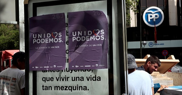 Unidos Podemos posters pasted on a street sign.