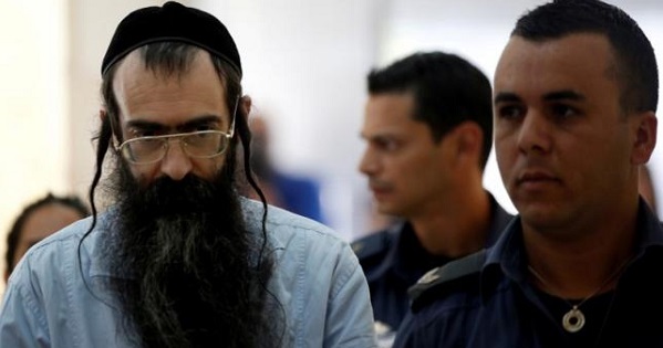 Yishai Schlissel is escorted by security personnel before he is sentenced at the Jerusalem District Court.