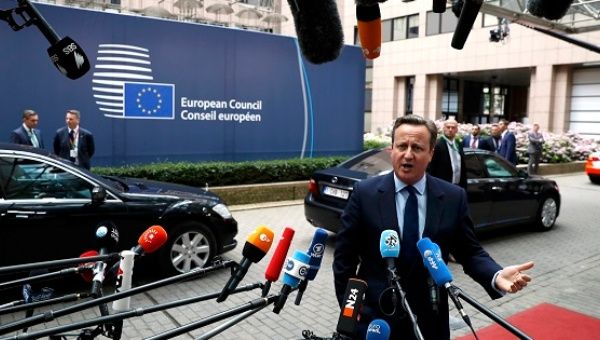 Britain's Prime Minister David Cameron talks to the media as he arrives at the EU Summit in Brussels, Belgium.