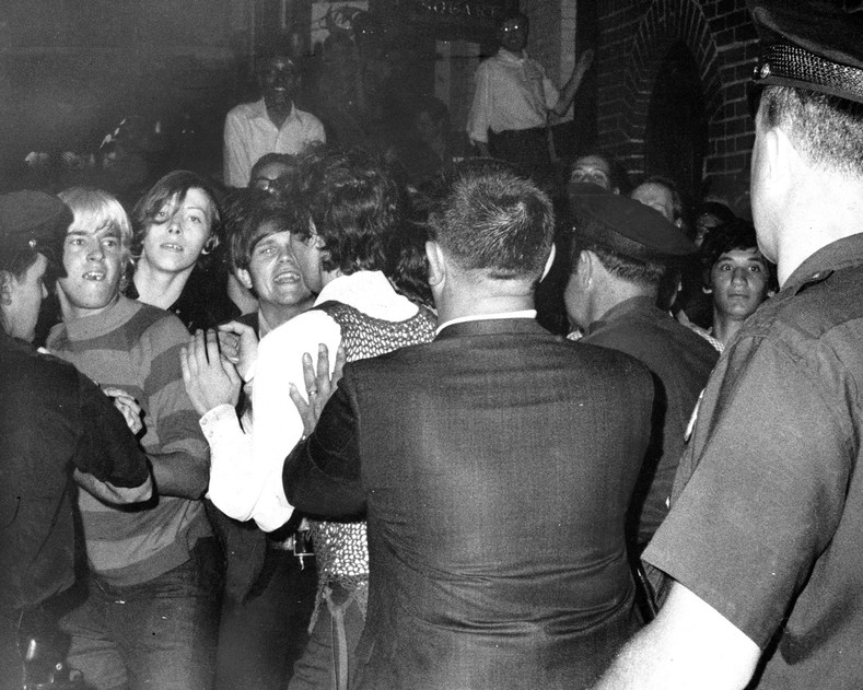 Police attempt to push people back outside of the Stonewall Inn as tensions escalate the morning of June 28, 1969.