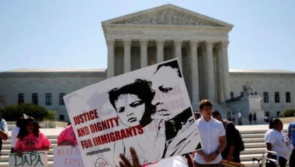 Demonstrators from the immigrant community advocacy group CASA carry signs as they march in the hopes of a ruling in their favor on decisions at the Supreme Court building in Washington, U.S. June 20, 2016.