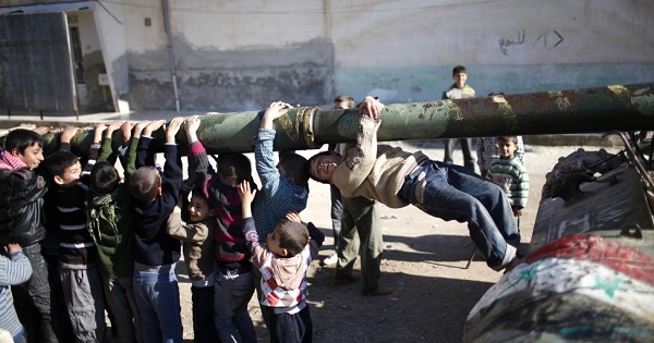 Children hang from the barrel of a tank, which was captured by the Free Syrian Army, in Azaz city, north Aleppo, Syria.