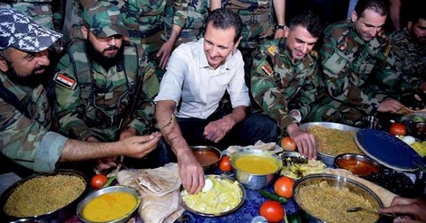 Syria's President Bashar al-Assad (C) joins Syrian army soldiers for Iftar in the farms in Damascus, Syria, in this handout picture, June 26, 2016.