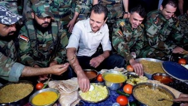 Syria's President Bashar al-Assad (C) joins Syrian army soldiers for Iftar in the farms in Damascus, Syria, in this handout picture, June 26, 2016. 