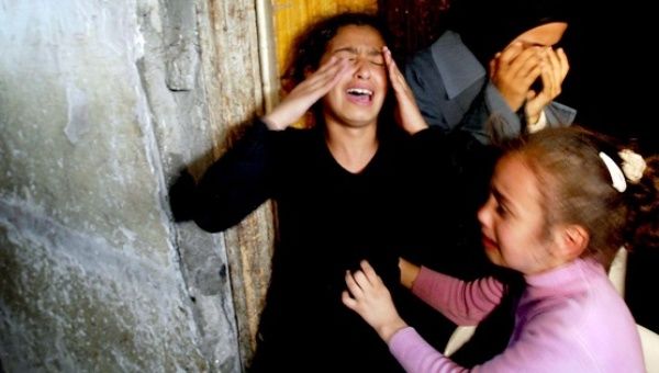 Two girls cry after their sister Mamdoh Abaid was killed in an Israeli airstrike.