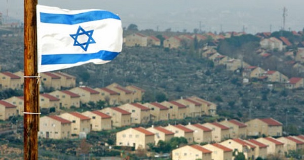 An Israeli flag flutters over the view of the illegal West Bank settlement of Ofra.
