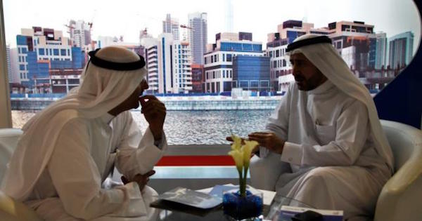 Businessmen speak to each other during the Cityscape real estate exhibition in Dubai, Oct. 2, 2012.