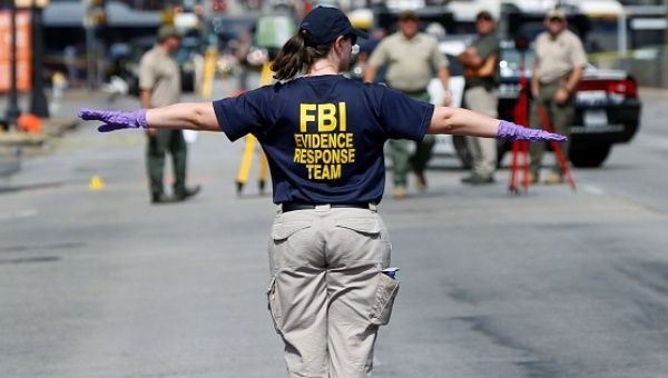A member of the FBI Evidence Response Team stands on Elm Street outside El Centro College in Dallas, Texas.