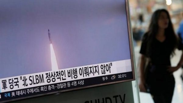 A passenger walks past a TV screen at a railway station in Seoul, South Korea, broadcasting a news report on North Korea's submarine-launched ballistic missile fired from North Korea's east coast port of Sinpo July 9, 2016.
