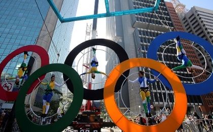 Acrobats perform on the Olympics rings at Paulista Avenue in Sao Paulo's financial center, Brazil, July 24, 2016. 