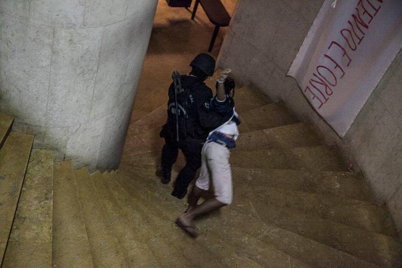 In a video Midia Ninja posted online, a woman can be seen being dragged down a set of winding stairs by police in riot gear.
