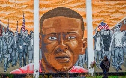 A man walks past a mural of Freddie Gray in the Sandtown-Winchester neighborhood of Baltimore, Maryland, U.S. on Dec. 17, 2015.