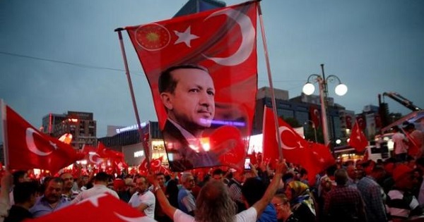 A supporter holds a flag depicting Turkish President Tayyip Erdogan during a pro-government demonstration in Ankara, Turkey, July 20, 2016.