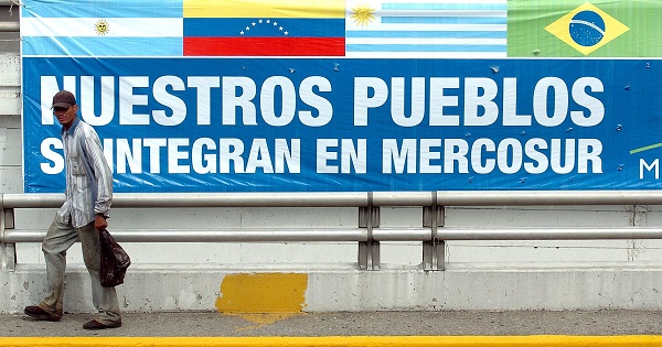 A man walks in front of a sign that reads, “Our peoples integrate in Mercosur,” ahead of a meeting of the bloc's heads-of-state in Caracas, Venezuela, July 4, 2006.