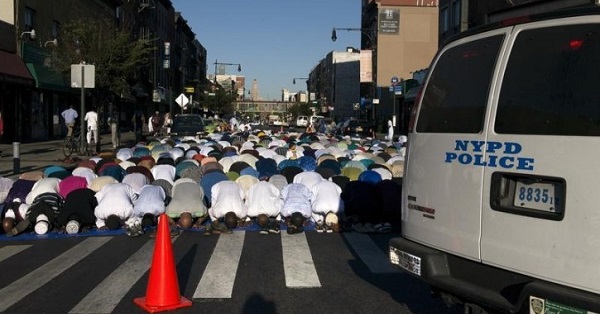 A New York Police Department vehicle is seen near worshipers as they take part in Eid Al-Adha prayers at the Masjid At-Taqwa mosque in Brooklyn.