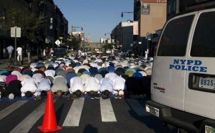 A New York Police Department vehicle is seen near worshipers as they take part in Eid Al-Adha prayers at the Masjid At-Taqwa mosque in Brooklyn.