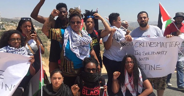 Black Lives Matter activists pose for a photo with local Palestinian activists during a protest in Bilin village near Ramallah, July 29, 2016.