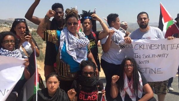 Black Lives Matter activists pose for a photo with local Palestinian activists during a protest in Bilin village near Ramallah, July 29, 2016. 