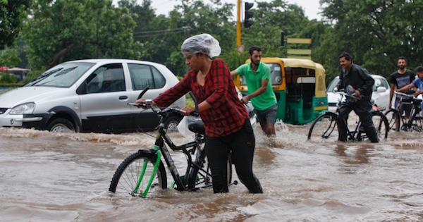 People commute through a flooded road after heavy rains in Chandigarh, India.