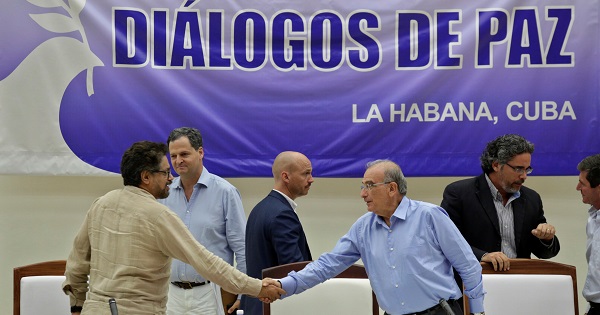 Ivan Marquez and Humberto de la Calle shake hands after signing the protocol