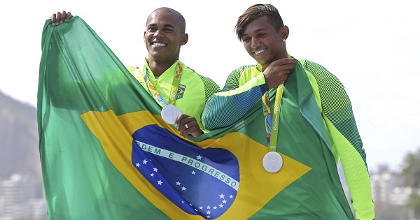 Brazilian rowers Erlon de Souza Silva (L) and Isaquias Queiroz Dos Santos pose with their national flag and silver medals.