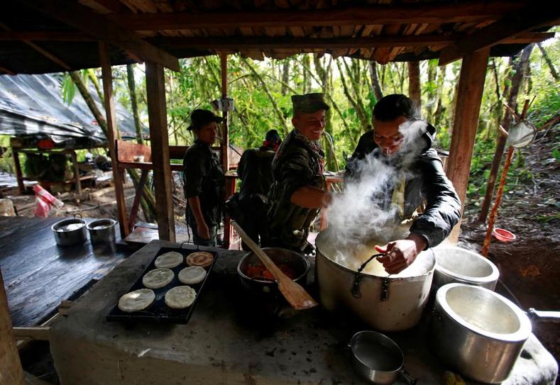 FARC rebels prepare a meal at a mountain camp. 