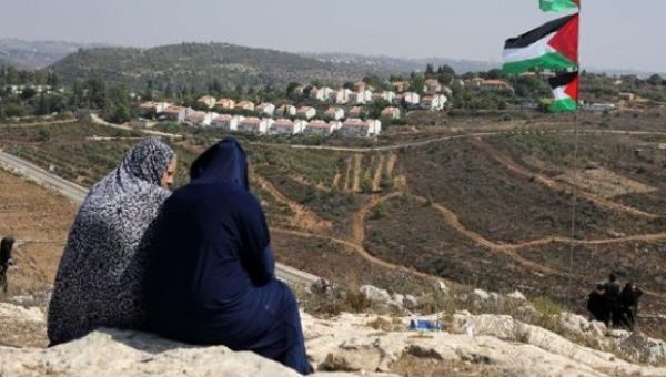 Palestinians look at the Jewish Hallamish settlement in the West Bank village of Nabi Saleh.