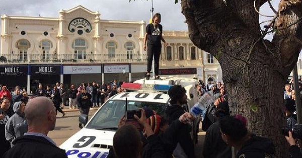 A protester stands on top of a police car during protests at the Kalgoorlie courthouse.