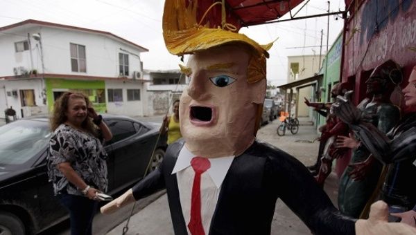 A man looks at a piñata depicting U.S. Republican presidential candidate Donald Trump hanging outside a workshop in Reynosa, Mexico, June 23, 2015.