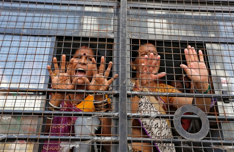 Women react from inside a police vehicle after their detention during a protest rally, as part of a nationwide strike, in Ahmedabad, India September 2, 2016. 