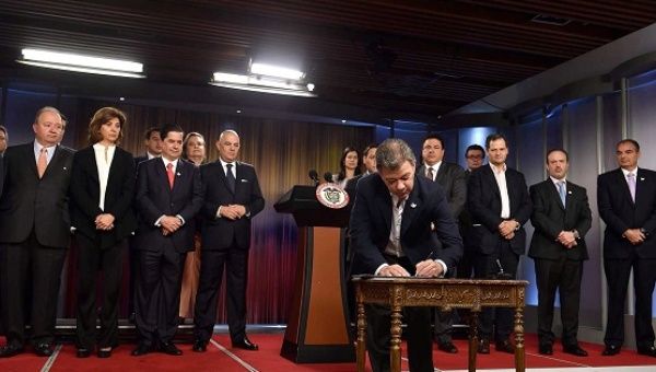 Colombia’s President Santos signs the plebiscite decree at the Narino palace in Bogota.