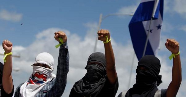 Masked students of UNAH raise their hands during a protest in Tegucigalpa, Honduras, July, 2016.
